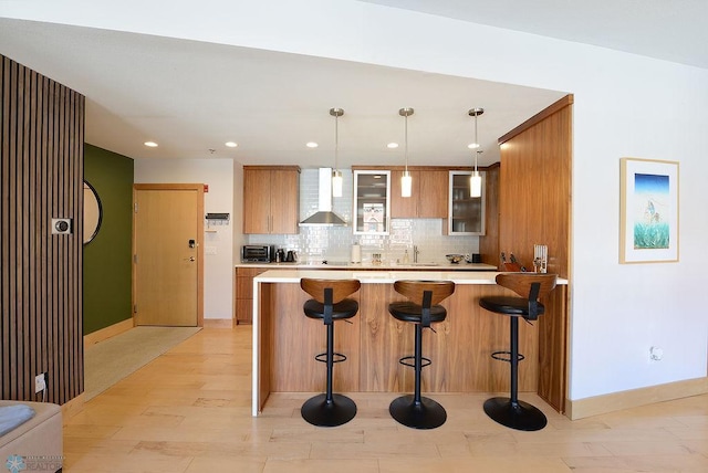 319 Broadway N Unit 202, Fargo, ND 58102 - kitchen featuring wall chimney exhaust hood, a breakfast bar, light countertops, a peninsula, and recessed lighting