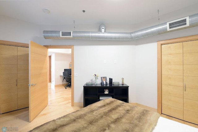 319 Broadway N Unit 202, Fargo, ND 58102 - bedroom with an office area, light wood-style floors, and baseboards