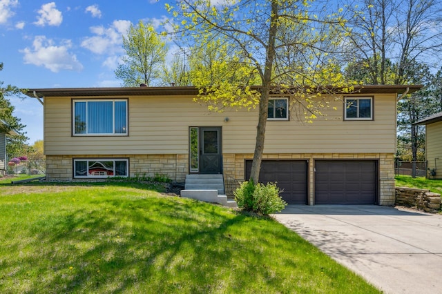 split foyer home with a garage, entry steps, a front yard, and driveway