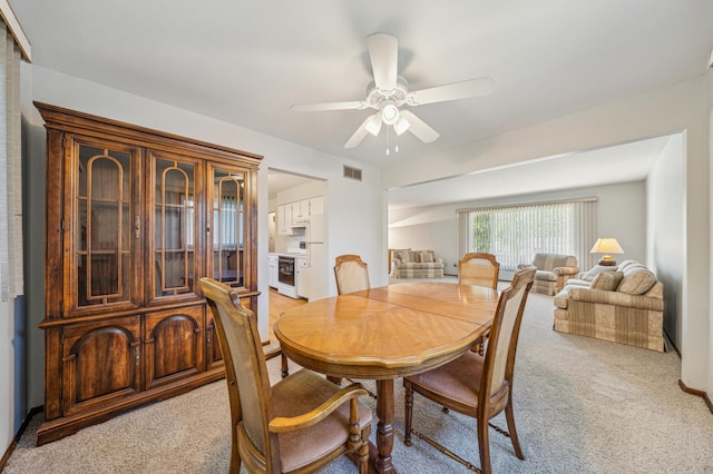 dining area featuring light colored carpet and ceiling fan