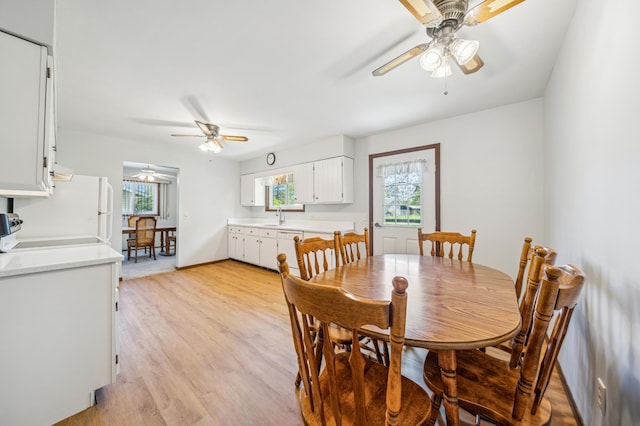 dining room featuring ceiling fan, light wood-style floors, and baseboards