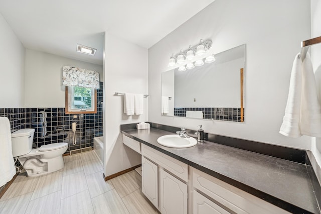full bathroom with toilet, tile walls, vanity, and tile patterned floors