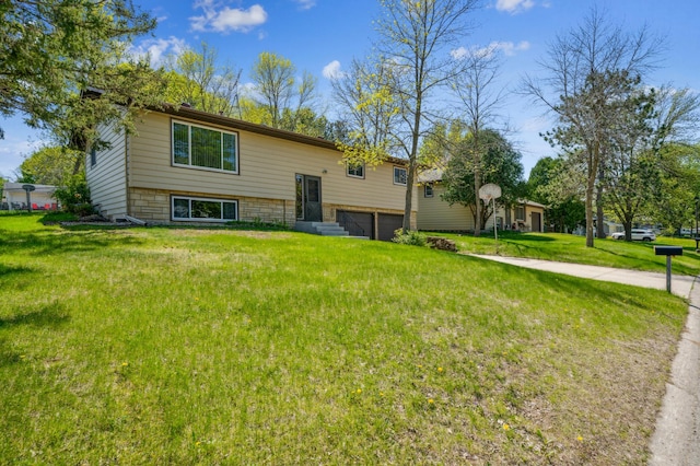 back of property featuring an attached garage and a yard