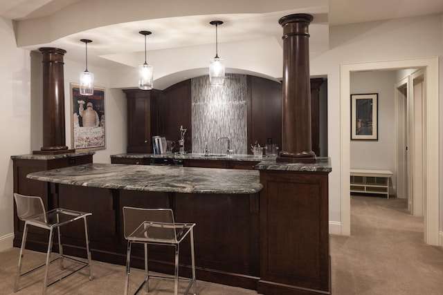 4812 Maple Rd, Edina, MN 55424 - indoor wet bar featuring ornate columns, light colored carpet, arched walkways, and hanging light fixtures
