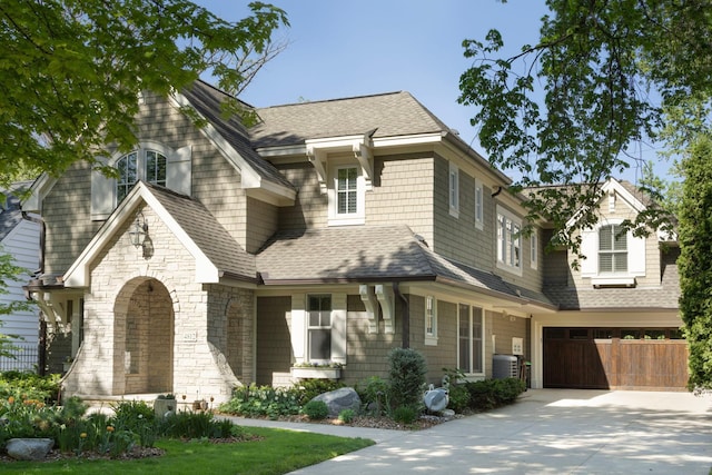 4812 Maple Rd, Edina, MN 55424 - view of front facade featuring concrete driveway, a garage, roof with shingles, stone siding, and cooling unit