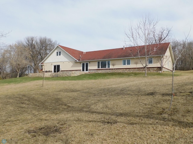 rear view of property featuring a lawn