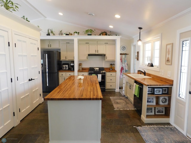 kitchen featuring a wealth of natural light, a sink, black appliances, and butcher block countertops