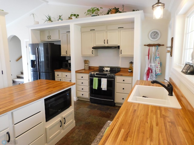 kitchen with black appliances, wooden counters, a sink, and under cabinet range hood