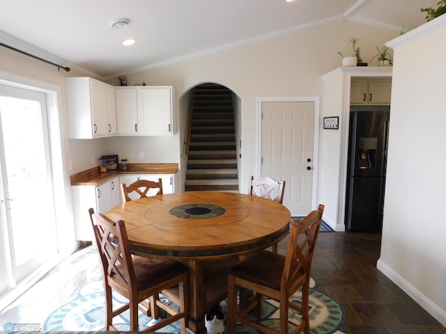 dining area with baseboards, stairs, crown molding, and stone tile flooring