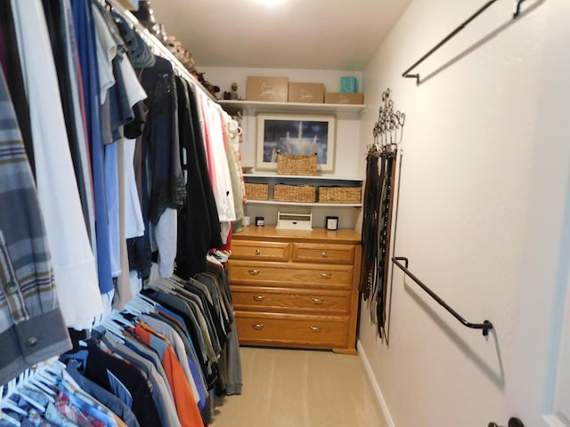 walk in closet with light carpet