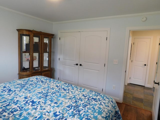 bedroom with crown molding, a closet, baseboards, and dark wood finished floors