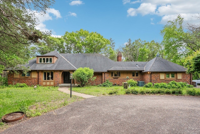 4810 Marystone Blvd NW, Andover, MN 55304 - view of front of home with central AC unit, a chimney, brick siding, a front yard, and a shingled roof