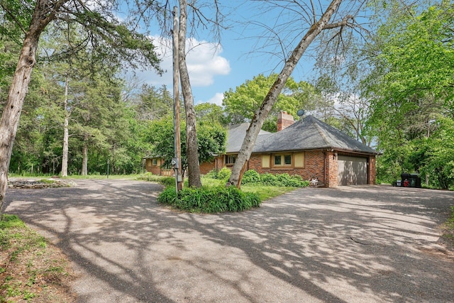 4810 Marystone Blvd NW, Andover, MN 55304 - view of front of house with asphalt driveway, a chimney, a garage, and brick siding