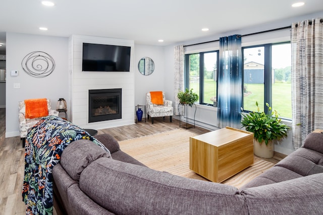 living area with a fireplace, wood finished floors, and recessed lighting