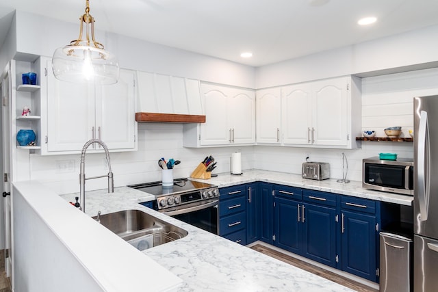 kitchen featuring open shelves, white cabinets, a sink, stainless steel appliances, and blue cabinetry