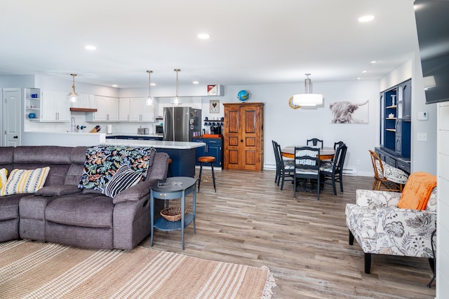living area featuring recessed lighting, baseboards, and light wood-type flooring