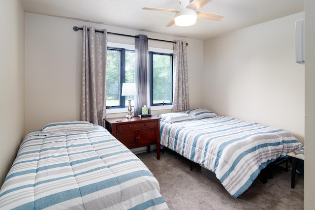 bedroom with a ceiling fan, carpet floors, and a textured ceiling
