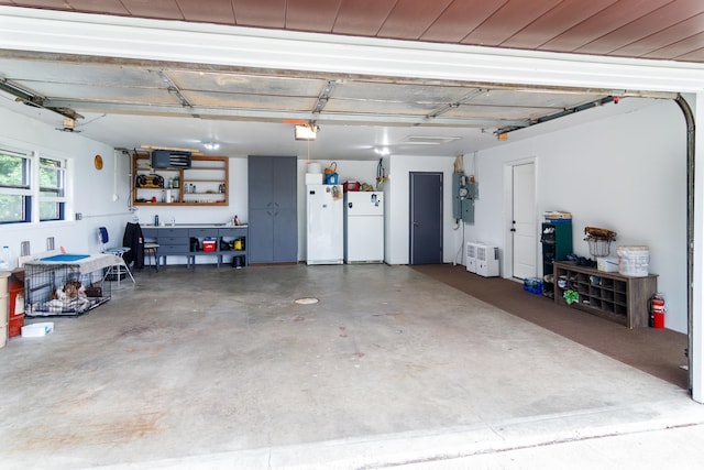 garage with a garage door opener and freestanding refrigerator
