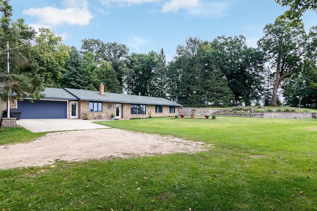 ranch-style home with a chimney, brick siding, a front yard, concrete driveway, and an attached garage