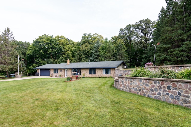 ranch-style house featuring a chimney, a front yard, concrete driveway, and an attached garage