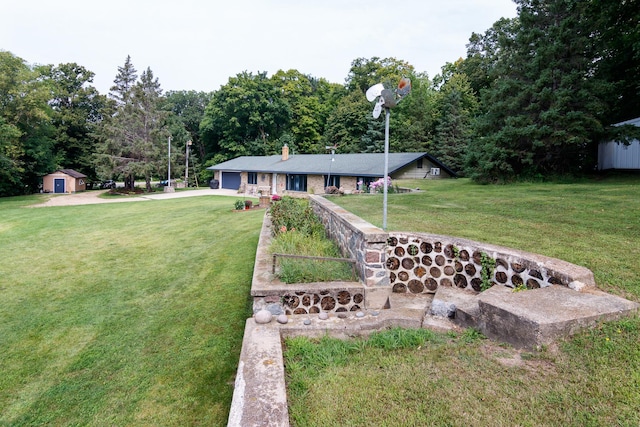 view of yard featuring a storage unit, an outdoor structure, concrete driveway, and an attached garage