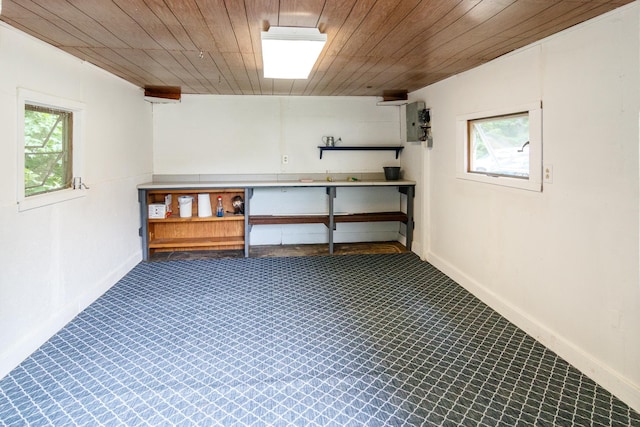 below grade area featuring wood ceiling, baseboards, and a healthy amount of sunlight