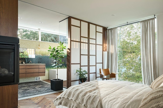 bedroom with a multi sided fireplace and floor to ceiling windows