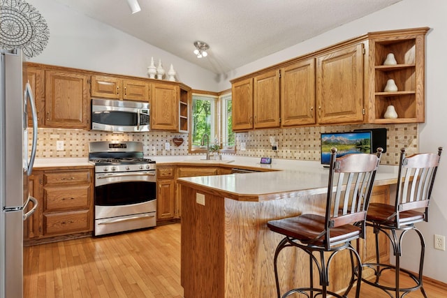 kitchen with stainless steel appliances, open shelves, a peninsula, a sink, and lofted ceiling