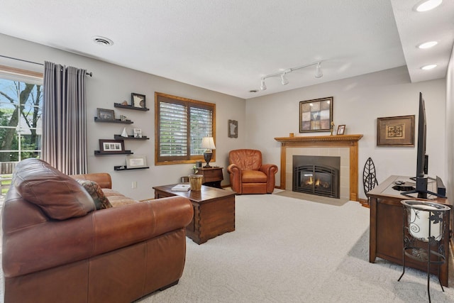 carpeted living room with a fireplace, plenty of natural light, recessed lighting, and track lighting