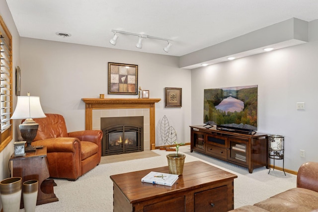 carpeted living room with a tiled fireplace, baseboards, and recessed lighting
