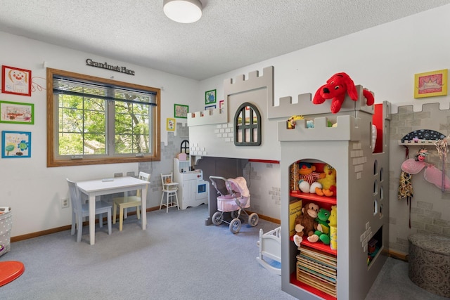 recreation room featuring a textured ceiling, carpet, and baseboards