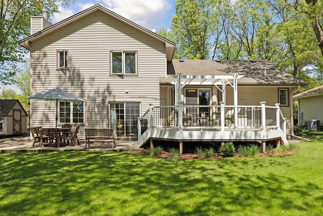 rear view of house with a pergola, a chimney, a deck, and cooling unit