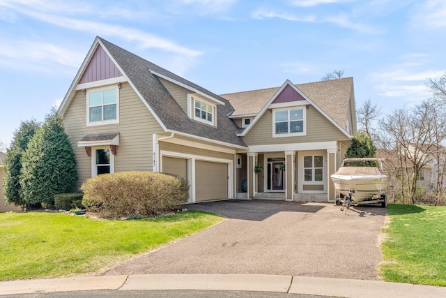 craftsman inspired home featuring an attached garage, a shingled roof, aphalt driveway, and a front yard