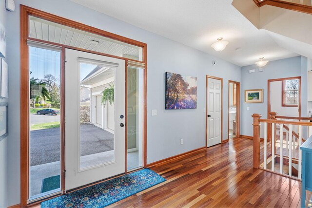 foyer with baseboards and wood finished floors