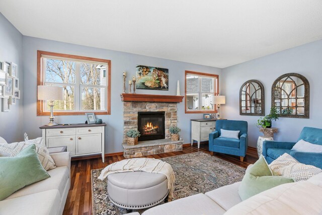 living area with baseboards, dark wood-style flooring, and a fireplace
