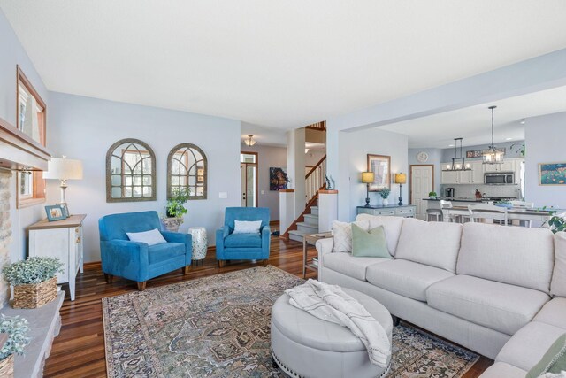living area featuring baseboards, dark wood-style floors, and stairway