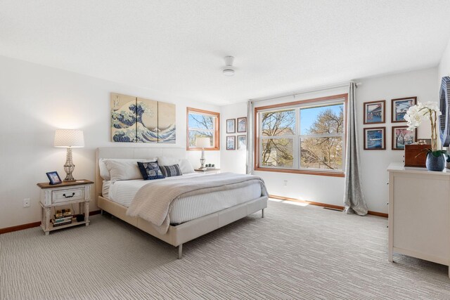 bedroom with baseboards and light colored carpet