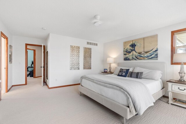 bedroom featuring visible vents, baseboards, and light carpet