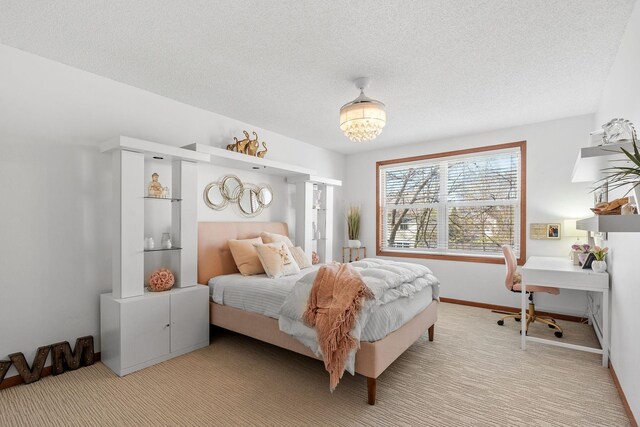 bedroom with a textured ceiling, light colored carpet, and baseboards