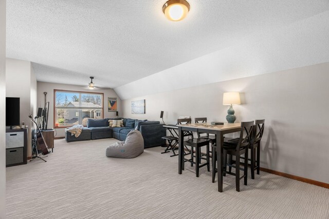 dining room with a ceiling fan, a textured ceiling, vaulted ceiling, carpet floors, and baseboards