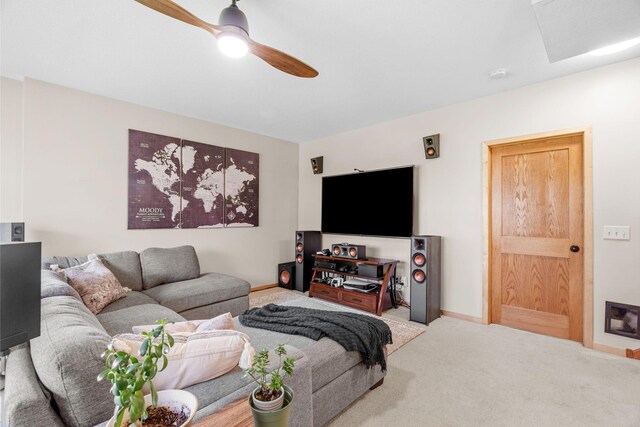 carpeted living area with a ceiling fan and baseboards