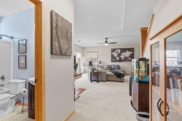 living room with a ceiling fan and carpet flooring