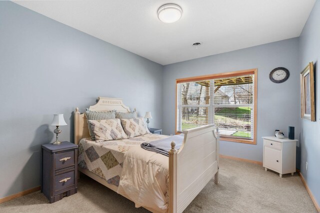 bedroom featuring baseboards, light colored carpet, and visible vents