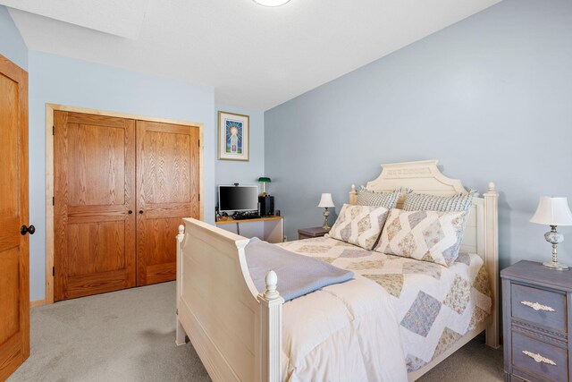 bedroom featuring light colored carpet and a closet