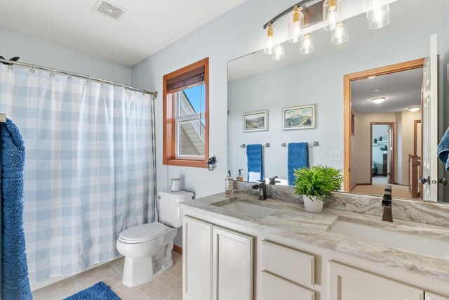 bathroom featuring visible vents, a sink, tile patterned flooring, and toilet