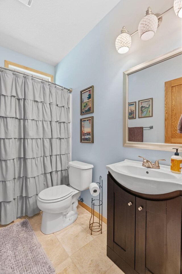 bathroom with vanity, baseboards, curtained shower, and toilet