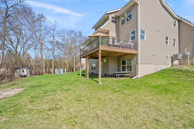 rear view of property featuring a wooden deck, a yard, and cooling unit