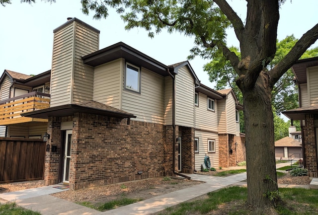 350 Ford Rd Unit 3, Saint Louis Park, MN 55426 - view of home's exterior with a balcony, brick siding, and a chimney