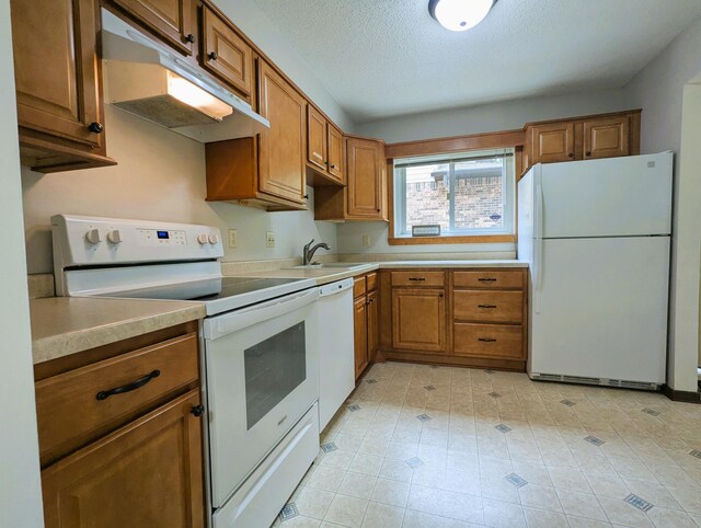 350 Ford Rd Unit 3, Saint Louis Park, MN 55426 - kitchen featuring white appliances, under cabinet range hood, brown cabinetry, a sink, and a textured ceiling