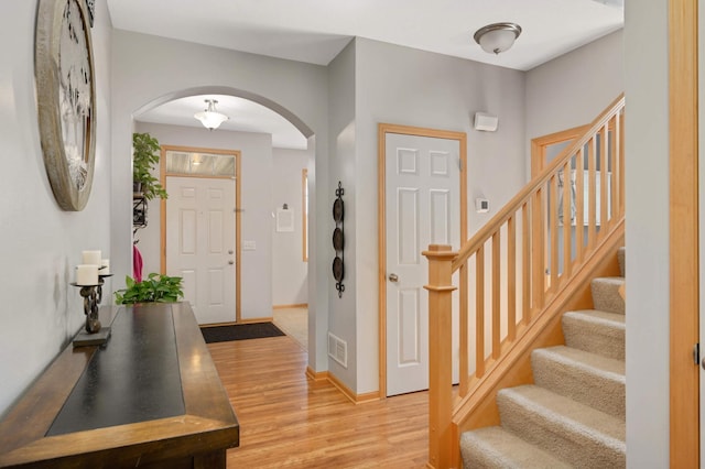 1810 Cherry Cir, Carver, MN 55315 - foyer featuring arched walkways, light wood-style flooring, and stairs